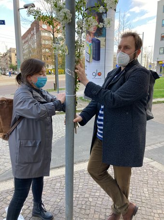 Constanze Mudra (LOPG) und Martin Biederstedt (Bündnis90/Die Grünen) bringen Wildkirschenzweig an